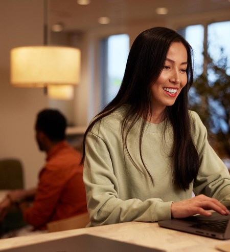 A young woman working on laptop smiling closeup